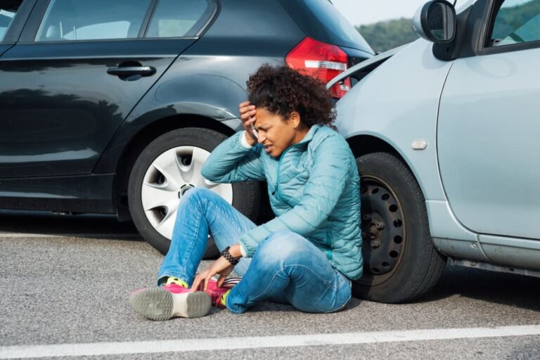 A injured lady sitting on road after rear-end accident in Wisconsin