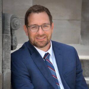 personal injury lawyer sitting on steps outside a business