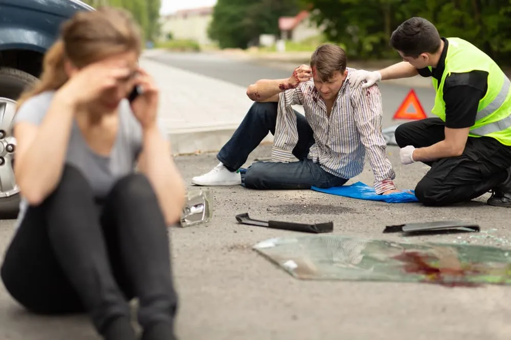 Two Victims Seated On Road 