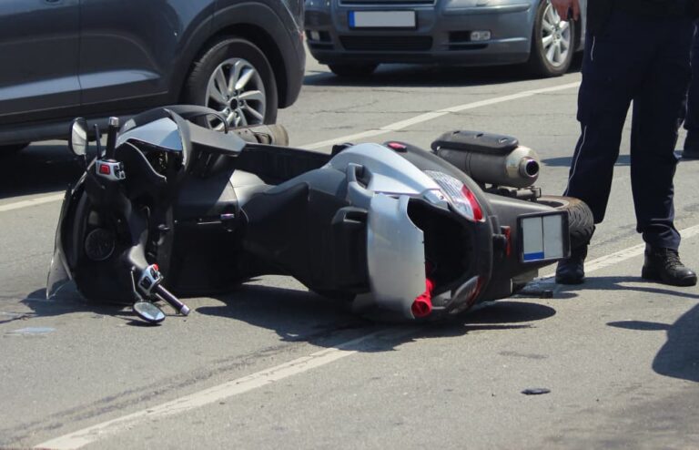 Traffic collision involving a car and scooter, motorbike accident on the road in Madison, Wisconsin.