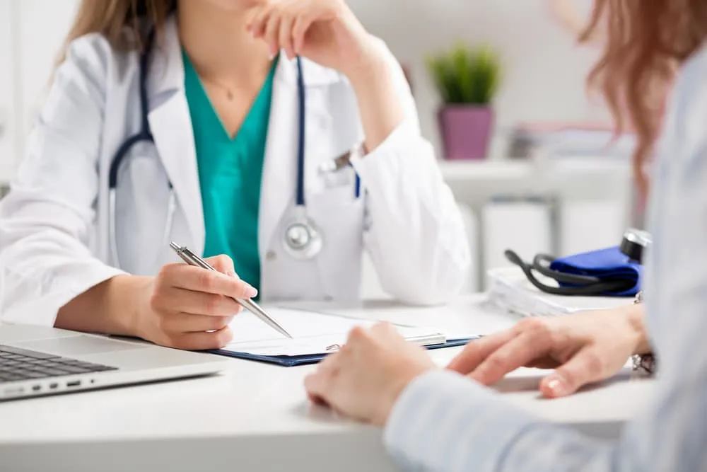 Closeup of doctor consulting patient in medical office. Women's healthcare and prevention.