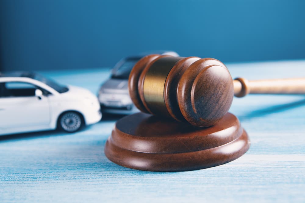 Car model next to a gavel, representing accident lawsuit, insurance, or court case.