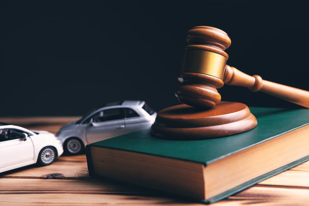 Car model next to a gavel symbolizing accident lawsuit, insurance, or court case.