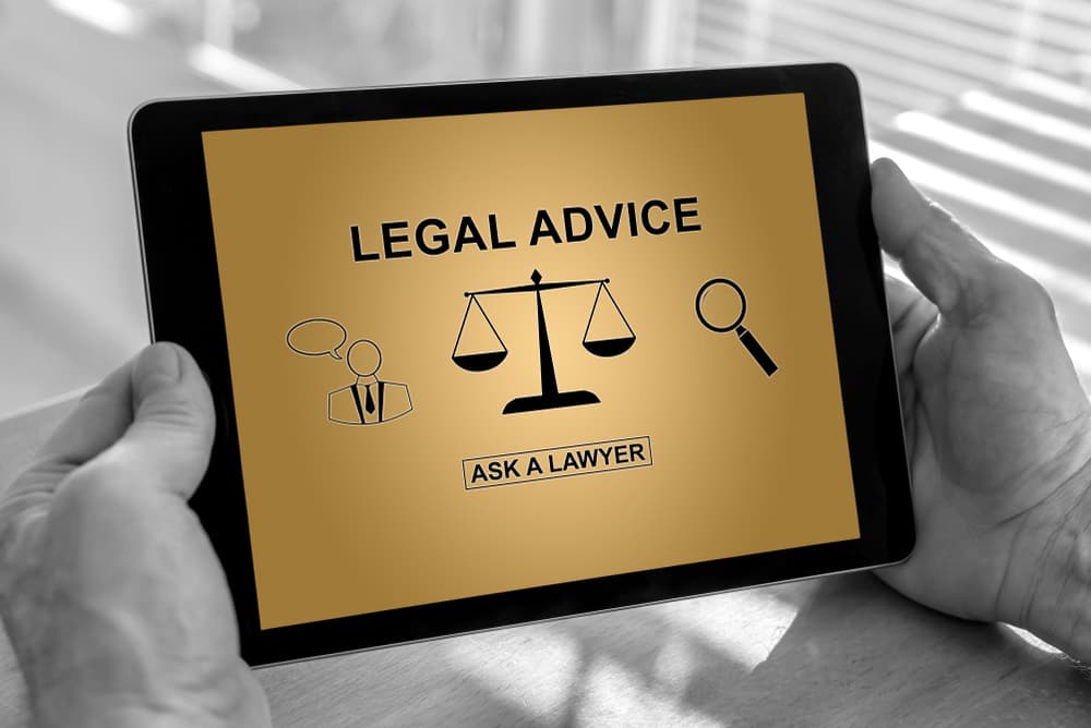 Hands of a man holding a tablet with legal advice concept.
