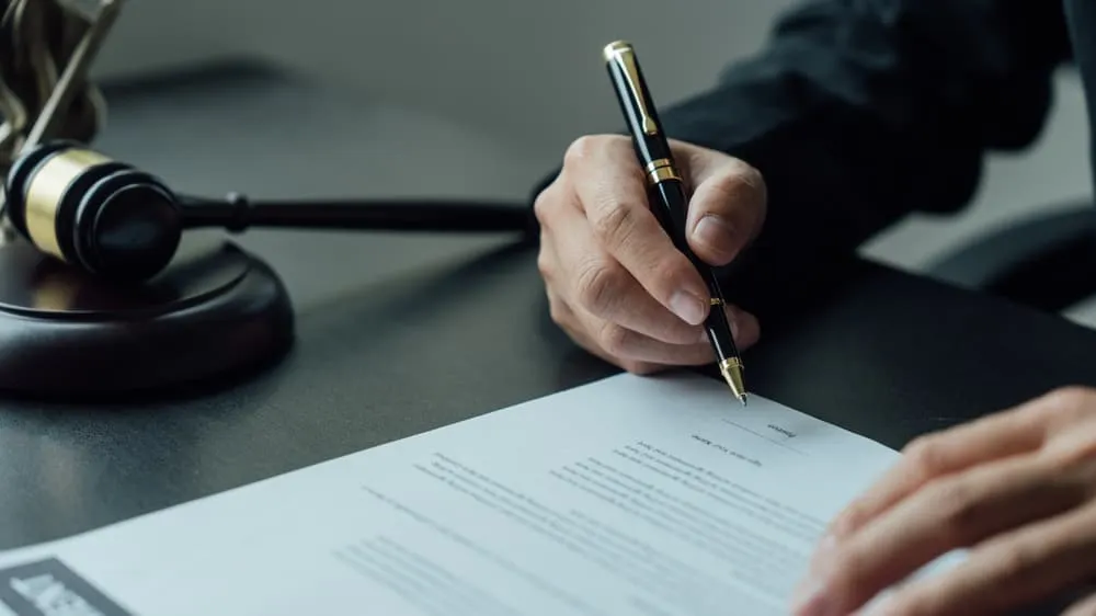 A legal consultant and an attorney review the contract signing agreement on behalf of an accident victim.