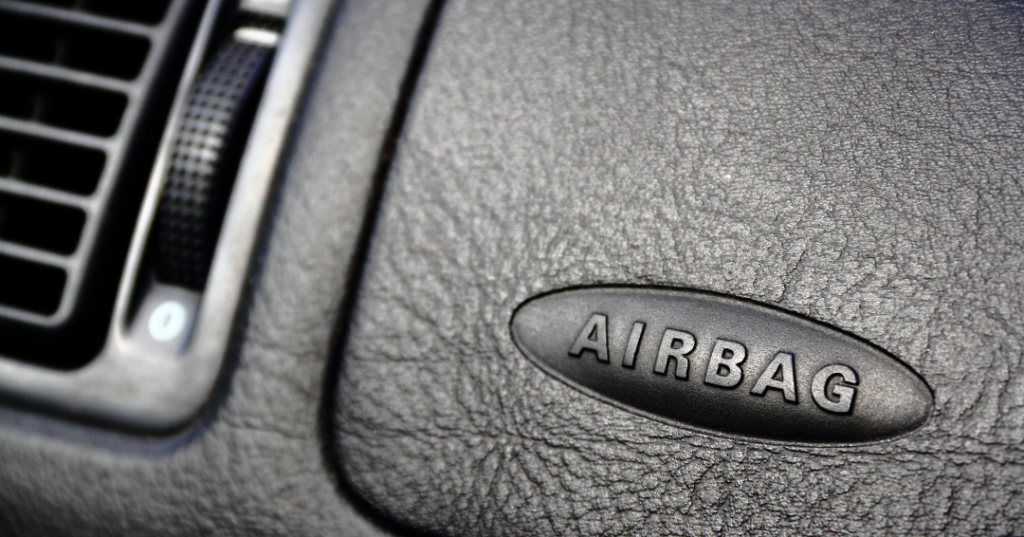 black dashboard of a vehicle with the word "AIRBAG" stylistically etched into it