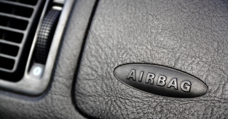 black dashboard of a vehicle with the word "AIRBAG" stylistically etched into it