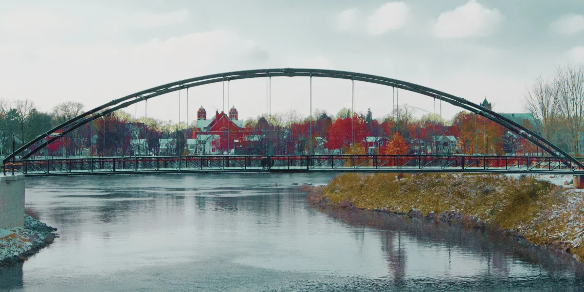 arch bridge over a river in eau claire, wisconsin with downtown buildings in the background