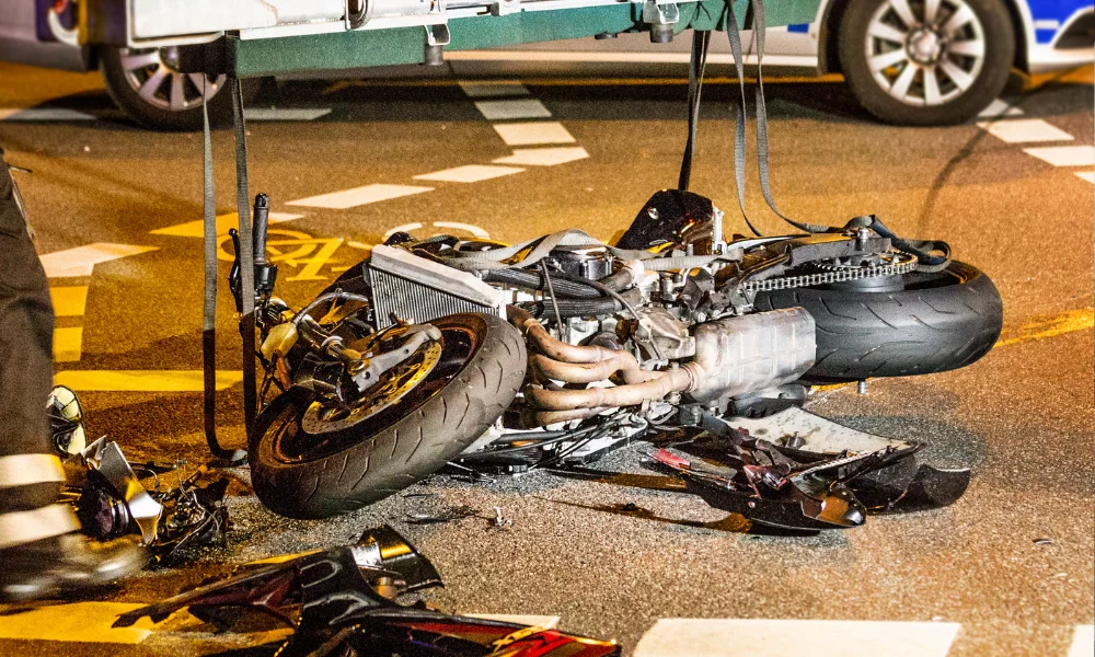 dented motorcycle on its side after an accident on a busy street