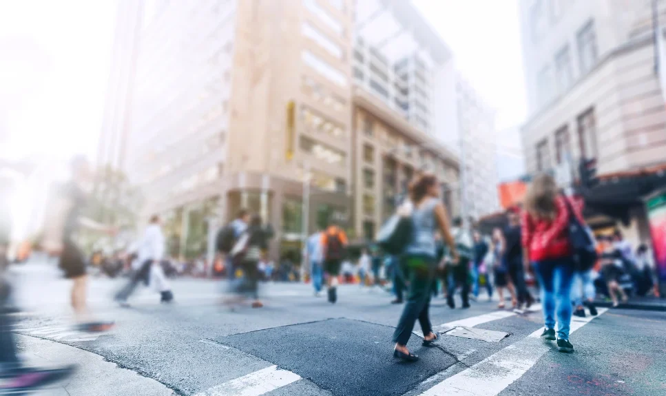 pedestrians cross a busy street in an urban area