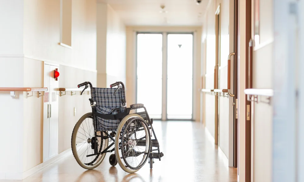 an empty wheelchair in the hallway of a nursing home or care facility