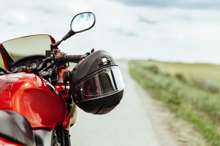 Black motorcycle helmet hanging on the handlebars of the motorcycle
