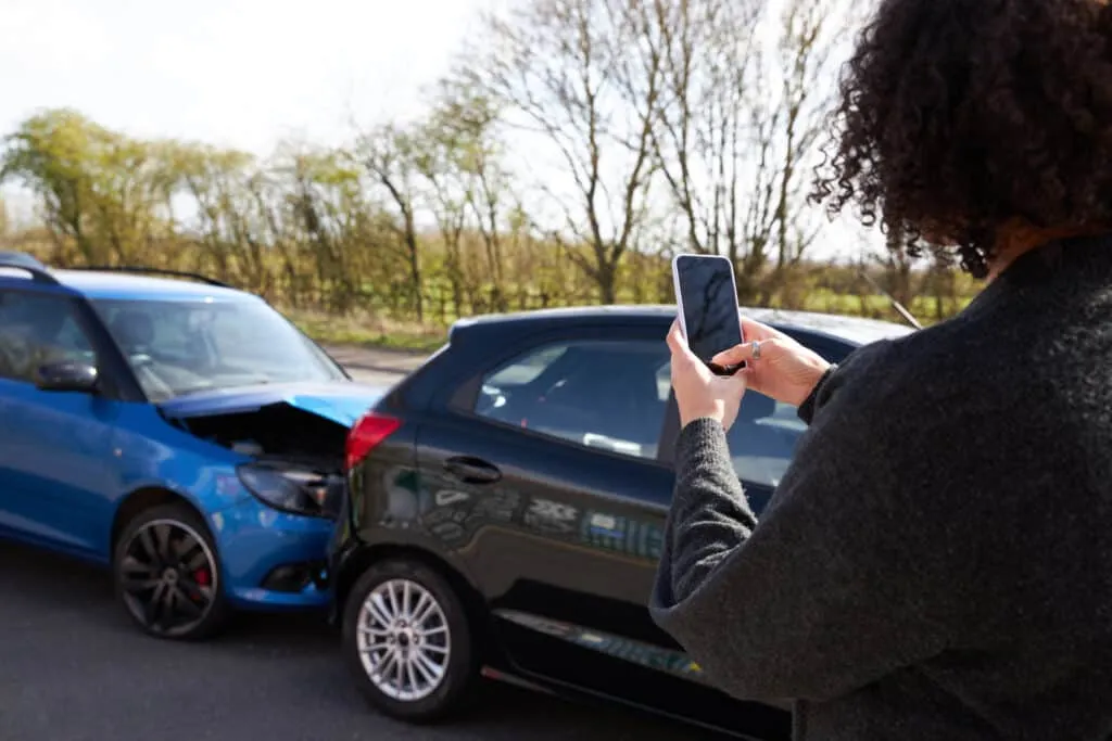 Female Driver Taking Photos After Car Accident