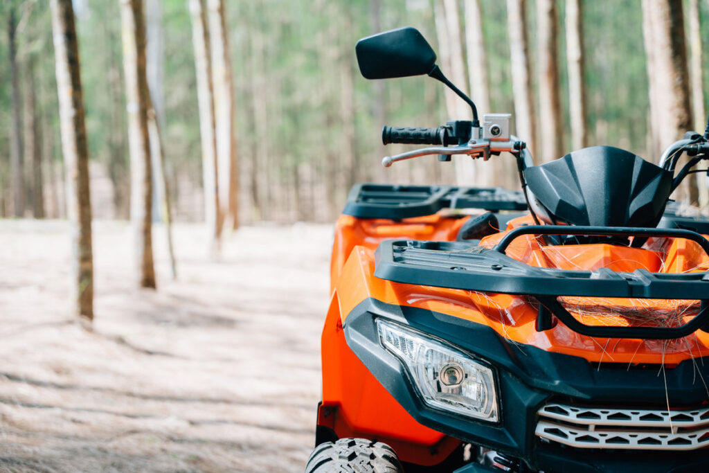 A quadbike competition in the autumn field, with the sun rising and the wheels kicking up mud and dirt, closeup Extreme recreation activity concept