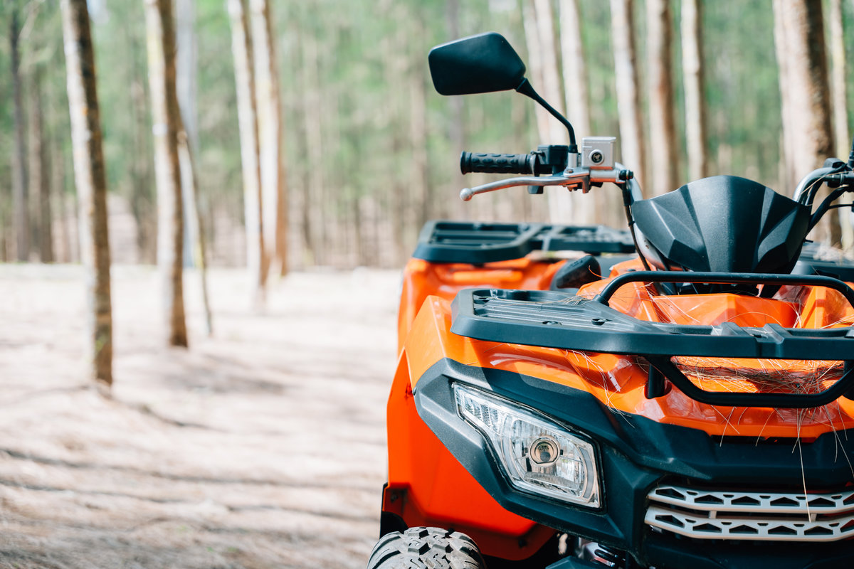 A quadbike competition in the autumn field, with the sun rising and the wheels kicking up mud and dirt, closeup Extreme recreation activity concept